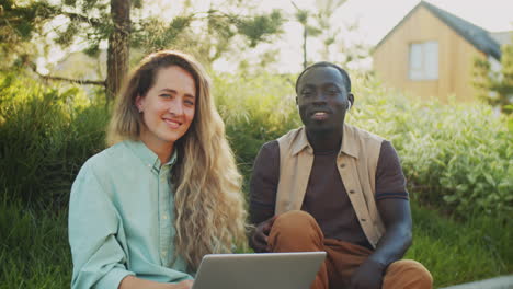 Portrait-of-Positive-Black-Man-and-Caucasian-Woman-with-Laptop-on-Street